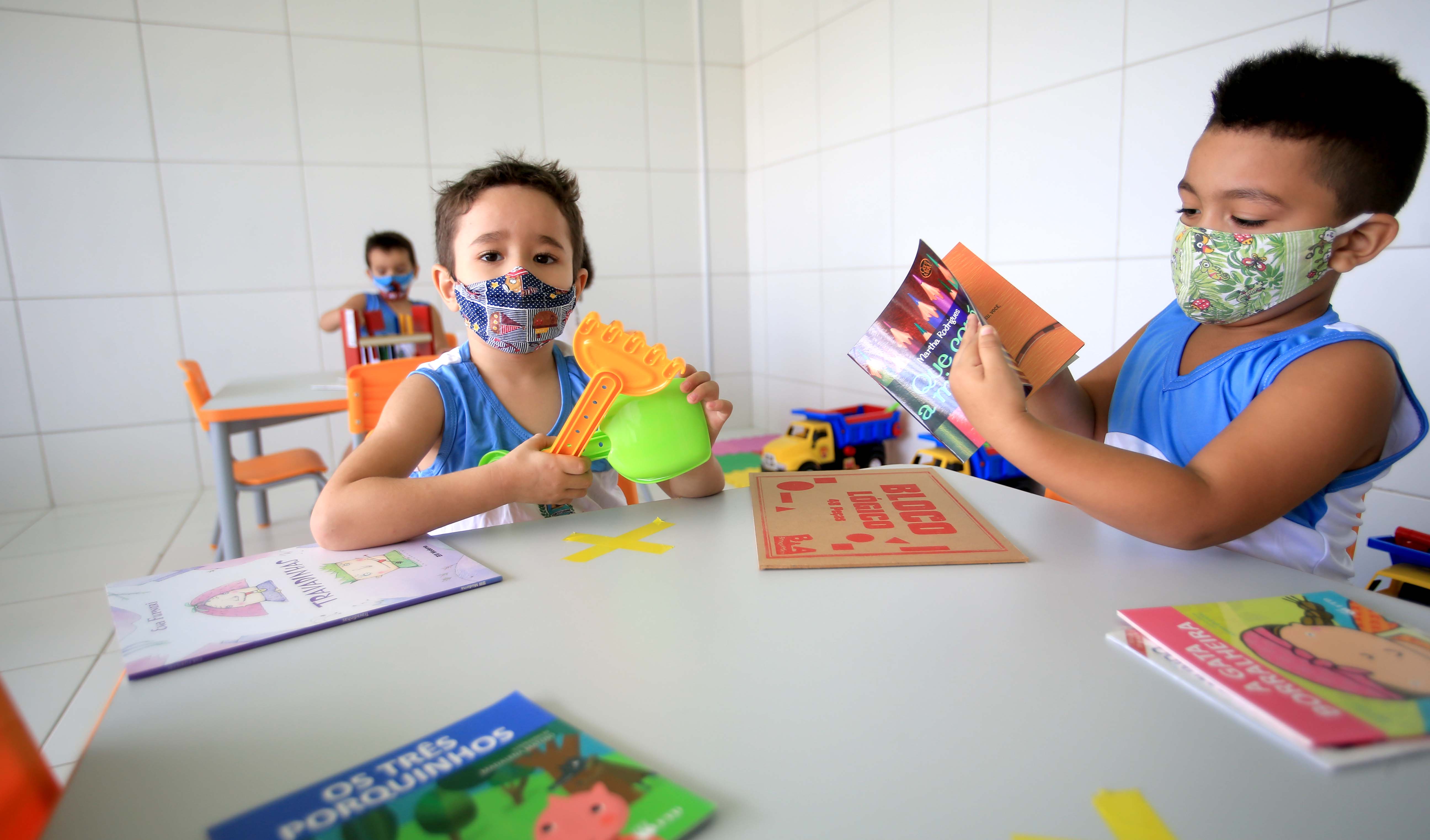 dois meninos brincando dentro de uma sala de um centro de educação infantil